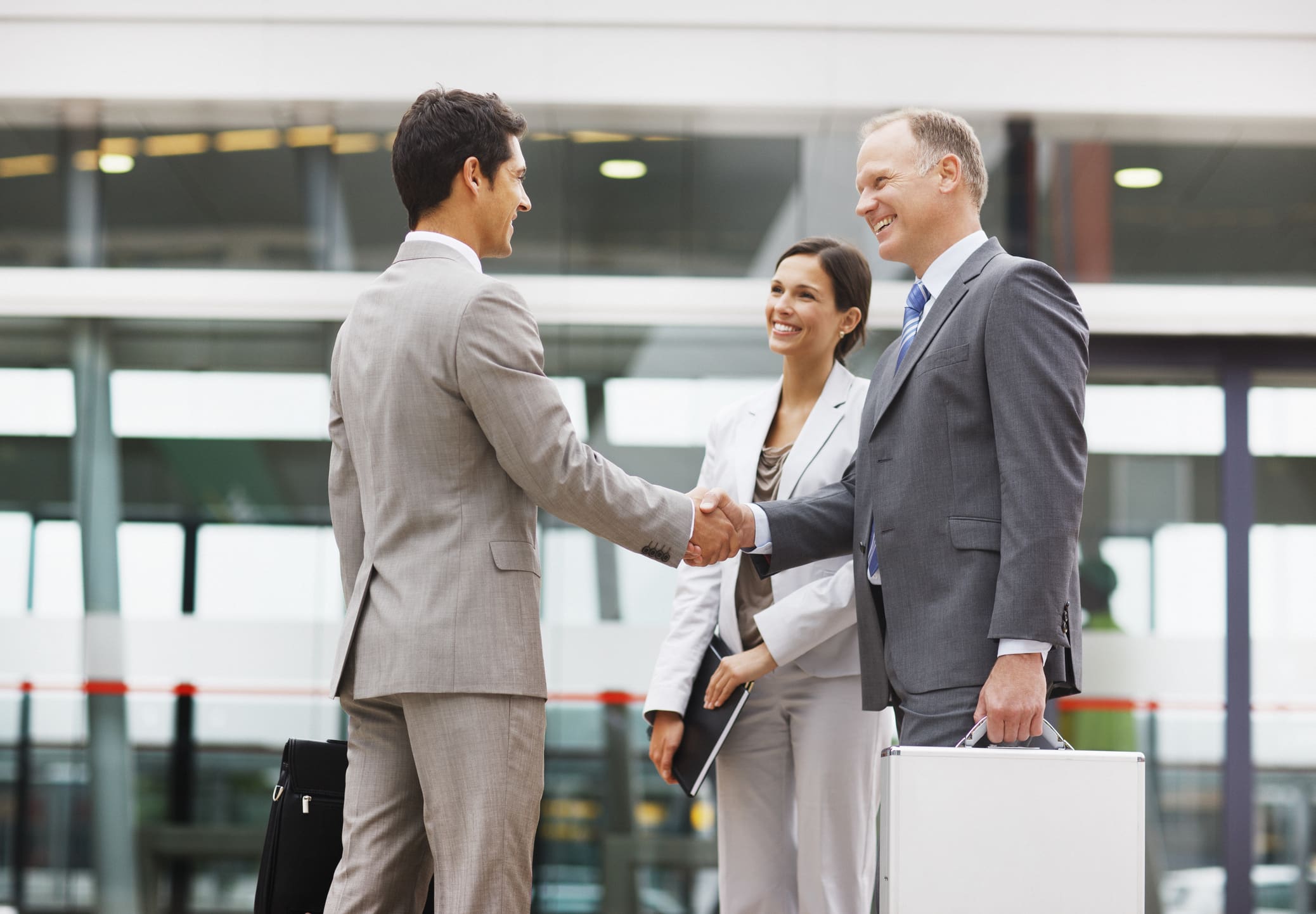 Business professionals shaking hands in a corporate setting.