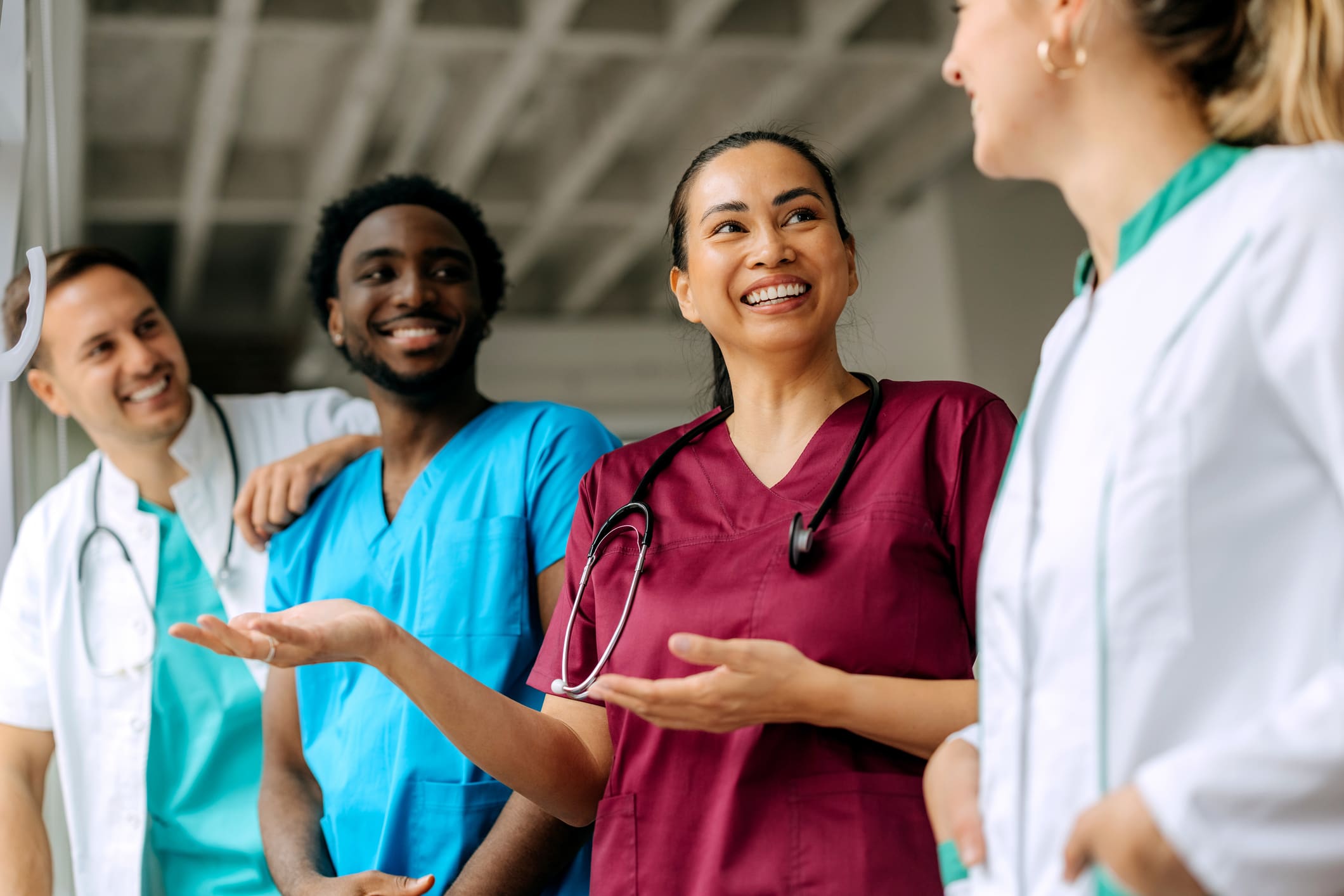 Three diverse healthcare professionals in discussion, smiling and engaging.